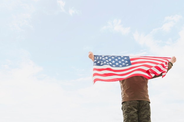 Foto uomo che tiene la bandiera americana