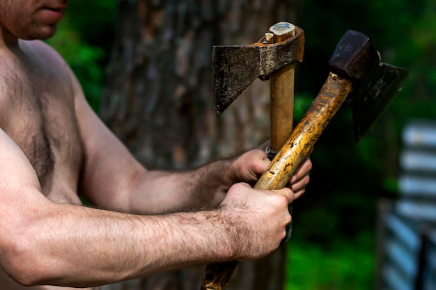 Man holding axes in nature