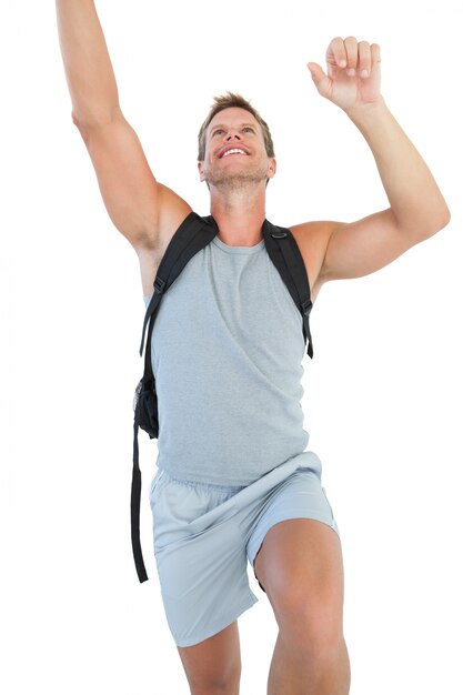 Man holding backpack and climbing