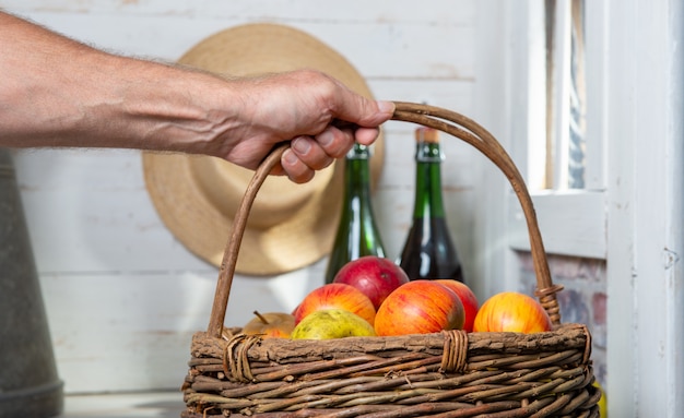 Man holding a basket full of apples