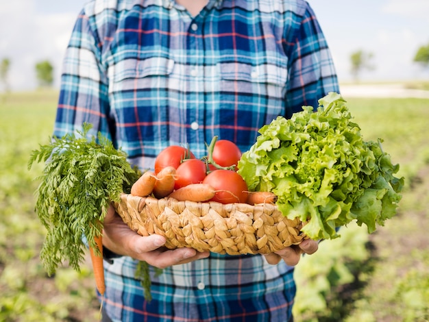 野菜がいっぱい入ったかごを持って男