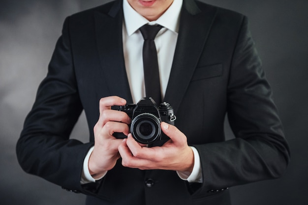 Photo man holding black digital camera