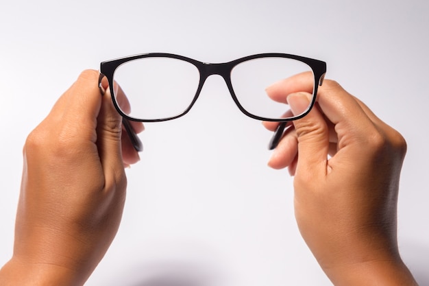 Man holding the black eye glasses spectacles with shiny black frame isolated on white