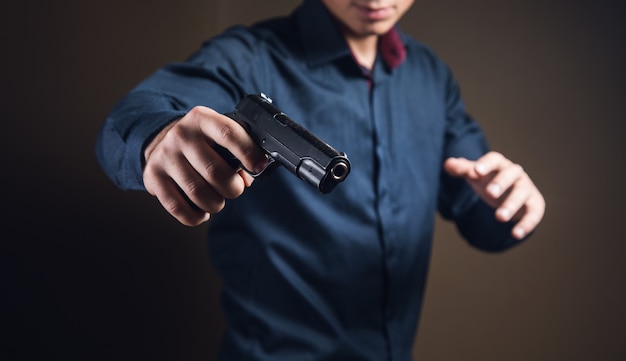 Foto un uomo con una pistola nera in mano minaccioso