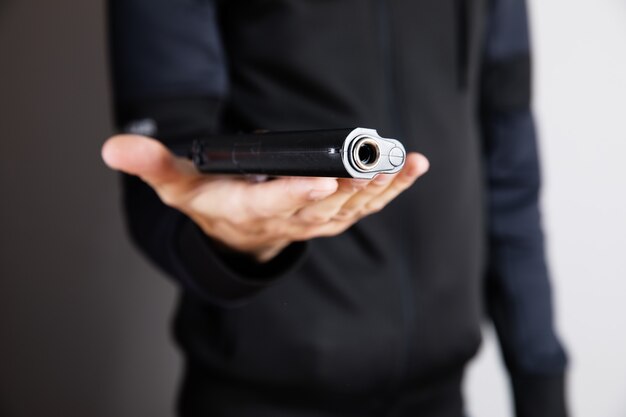 A man holding a black pistol in his hand threatening