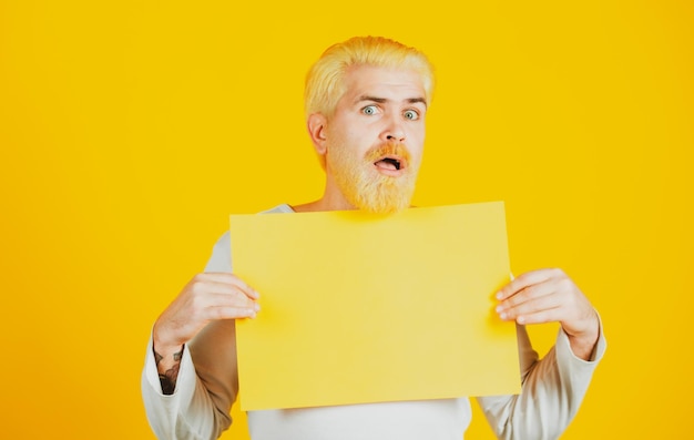 Man holding a blank sheet of paper isolated on yellow background