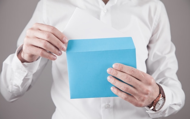 Man holding blue mail envelope.