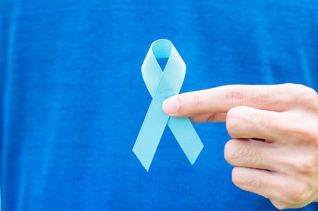 Man holding Blue Ribbon with mustache for supporting Movember