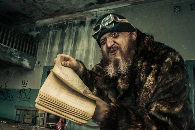 Photo man holding book in abandoned building