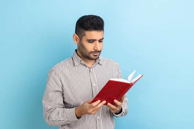 Man holding book and reading standing absorbed with exciting plot checking schedule in notepad