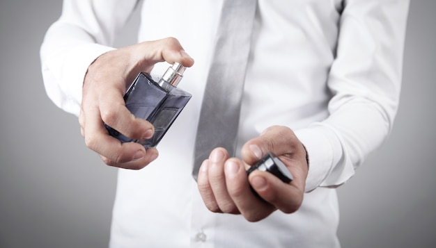 Man holding a bottle of perfume.