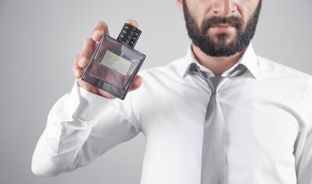 Man holding a bottle of perfume.