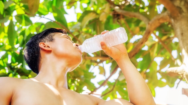 水のボトルと飲み物を持って男。