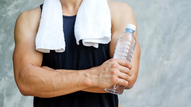 水のボトルを保持している男。