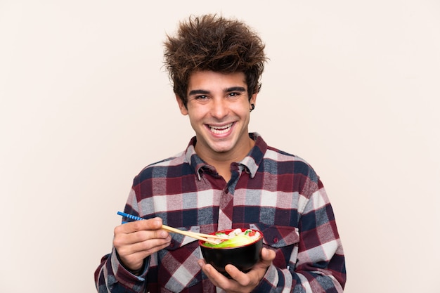 Man holding a bowl full of noodles