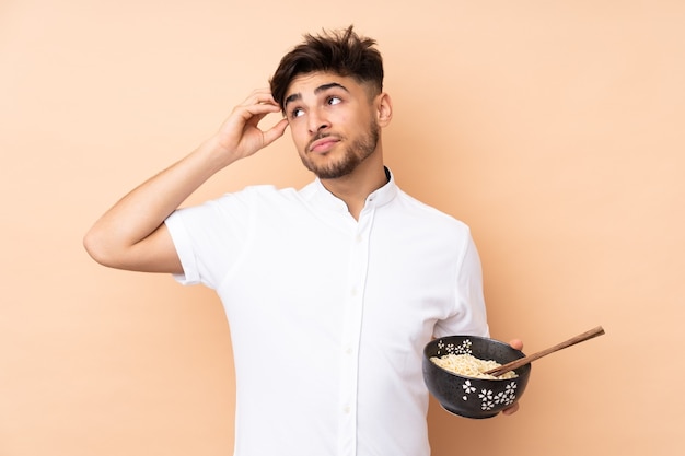 Man holding a bowl of noodles soup