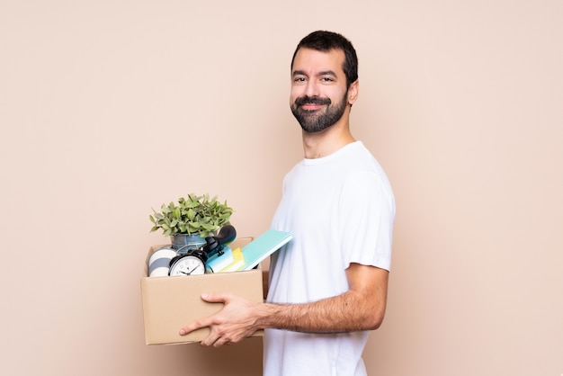 Man holding a box and moving in new home over isolated background