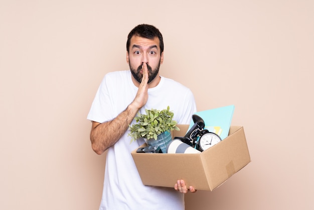 Man holding a box and moving in new home keeps palm together, Person asks for something
