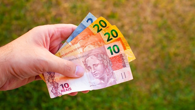 Photo a man holding brazilian real bills