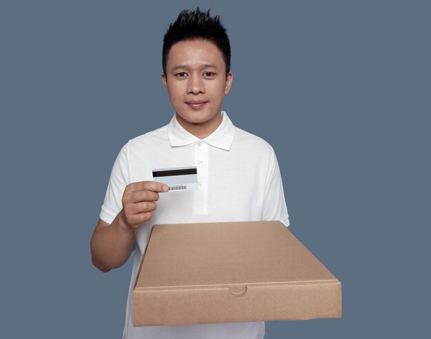 Man holding brown cardboard box and credit card isolated on plain background