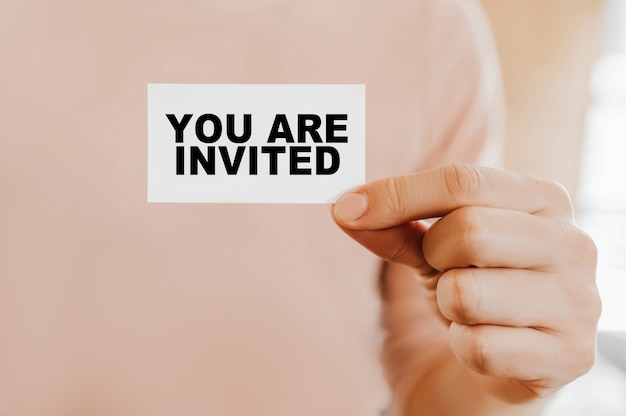 Photo man holding a business card with you are invited