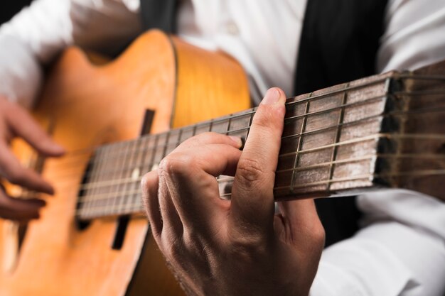 Uomo che tiene l'accordo di barra maggiore di c sulla chitarra