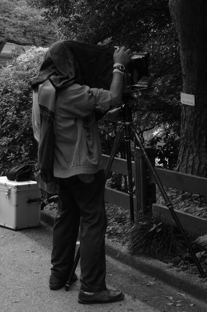 Man holding camera while standing on land