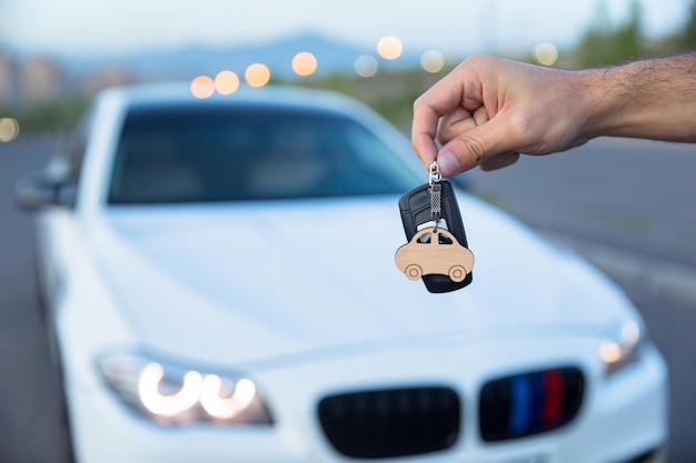 背景に車で車のキーを保持している男