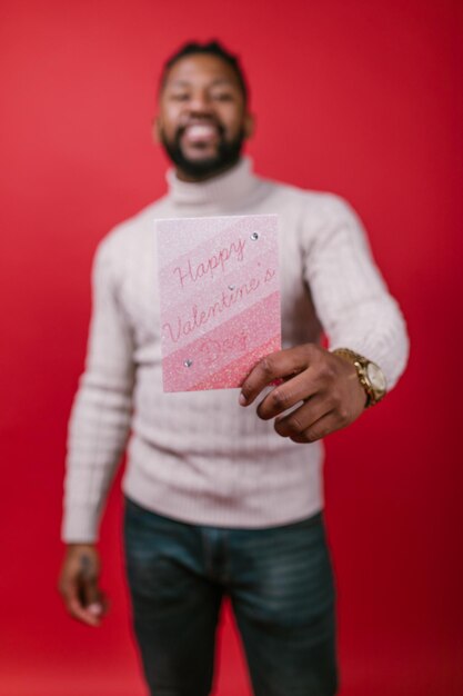 Photo a man holding a card that says happy valentine.