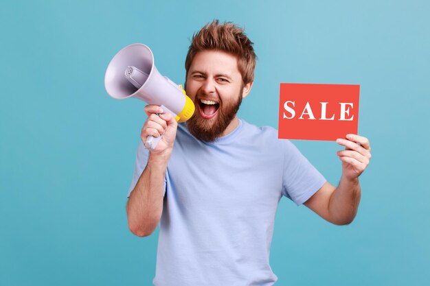 Man holding card with sale inscription and screaming in megaphone about discounts