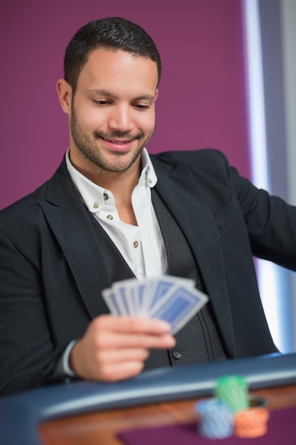 Uomo che tiene le carte sorridendo