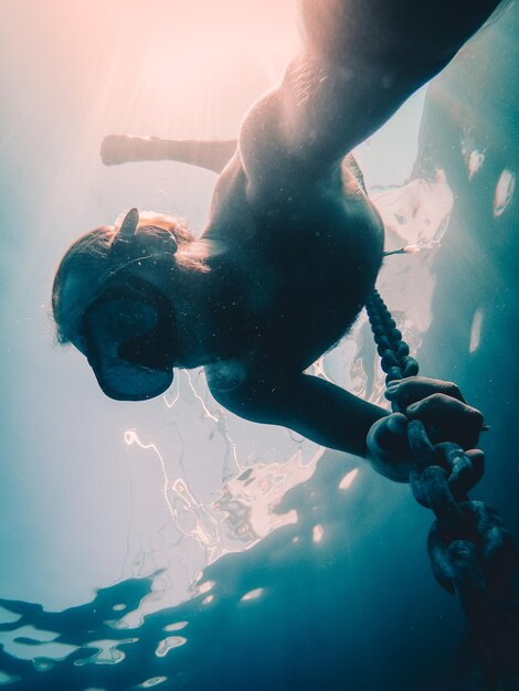 Foto uomo con una catena in mare