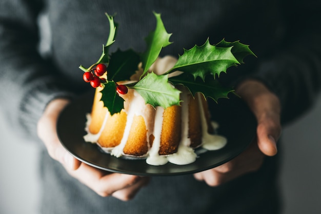 Uomo che tiene la torta di natale con deco