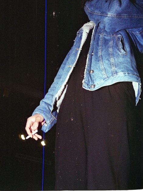 Photo man holding a cigarette in the dark