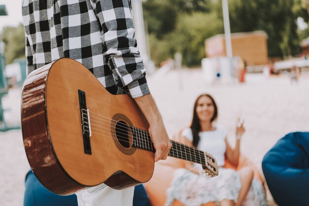 Photo man holding classical guitar friends have rest