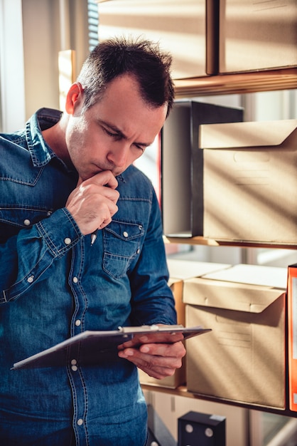 Man holding clip board and reading document at the office