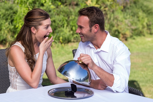 Man holding cloche while proposing woman