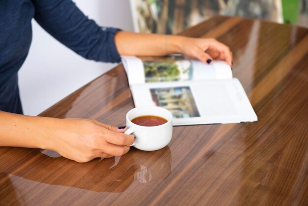 Foto uomo che tiene una tazza di caffè sul tavolo