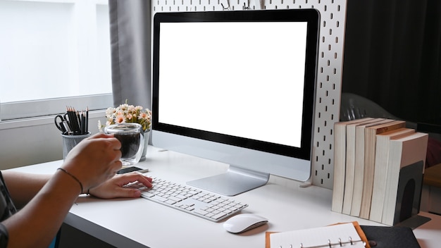 Man holding coffee cup and working with computer at home office.