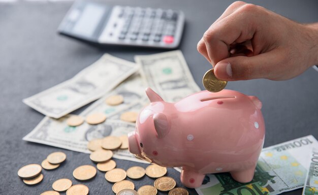 Man holding coin with piggy bank