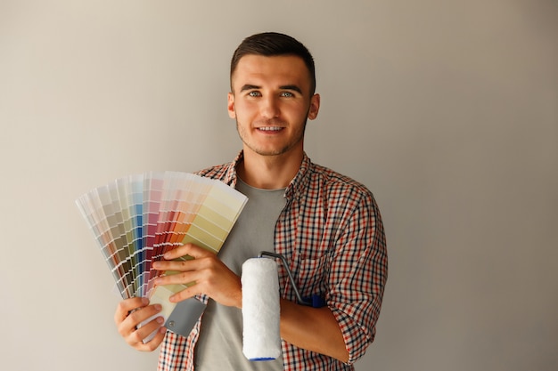 Man holding color palette and paint roller