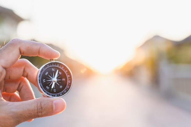 Man holding compass on blurred background. for activity lifestyle outdoors freedom or travel tourism and inspiration backpacker alone tourist travel or navigator image.