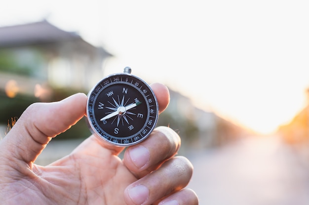 Man holding compass on blurred background. for activity lifestyle outdoors freedom or travel tourism and inspiration backpacker alone tourist travel or navigator image.