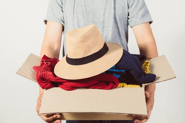 Man holding a crate of secondhand clothes unused clothes