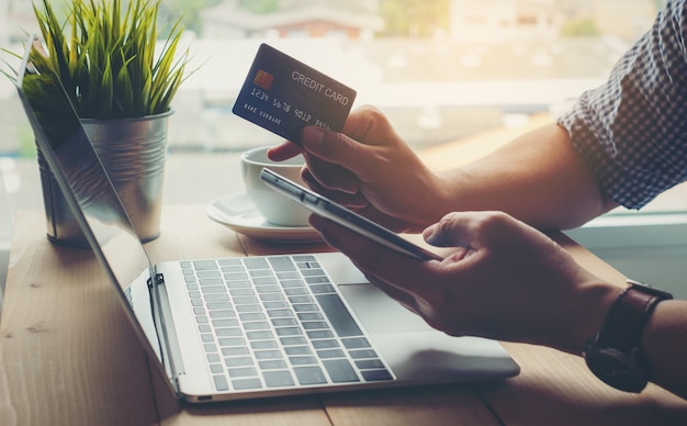 Фото Человек, держащий кредитную карту, совершает покупки онлайн на смартфоне