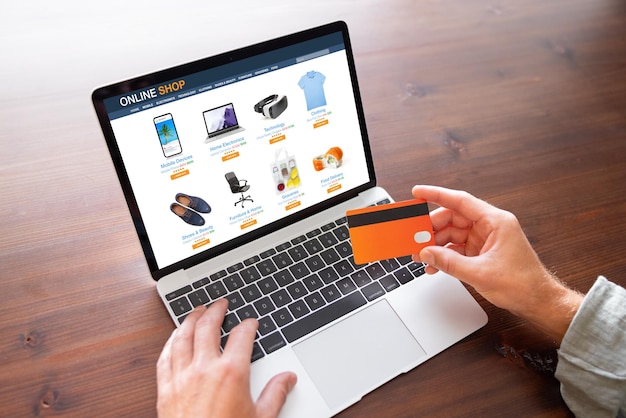 Man holding credit card and shopping at online store on laptop computer