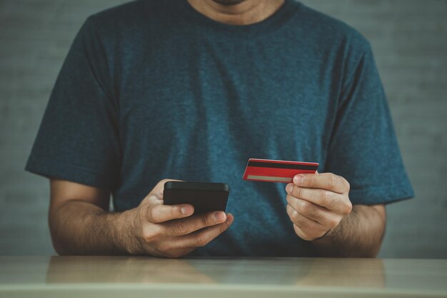 Man holding credit card and using laptop computer Businessman working at home Online shopping ecommerce internet banking spending money working from home concept