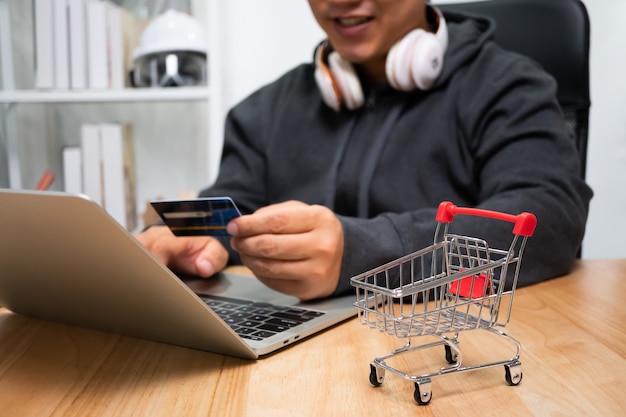 A Man holding credit card and using laptop for payment online