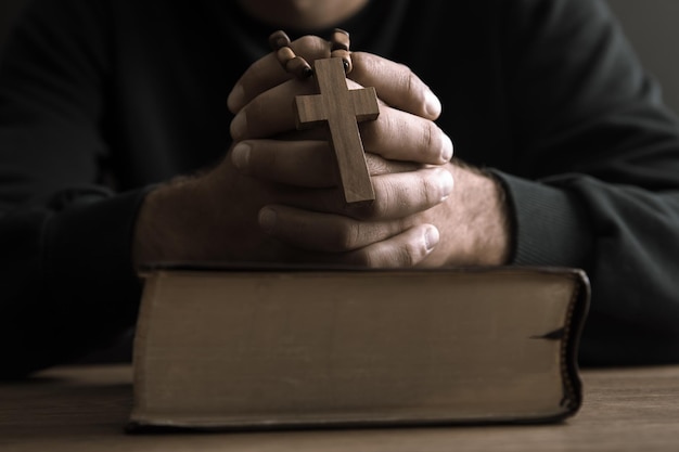 Photo man holding cross with holy bible