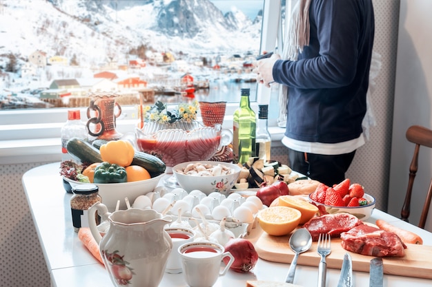 冬の観光ビューとカップを保持しているとクリスマスの食べ物を準備する男